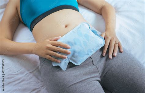 Woman Holding Hot Water Bag On Her Stomach In Bedroom Female Lying In Bed Stock Photo Adobe Stock