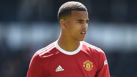 Mason Greenwood Is Standing In Blur White Black Backgroud Wearing Red