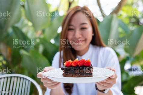 Portrait Image Of A Beautiful Young Asian Woman Holding And Eating A