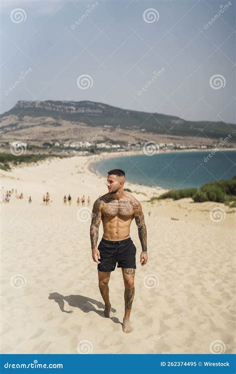 Handsome Half Naked Caucasian Man Walking On The Sand Enjoying His Vacation Stock Image