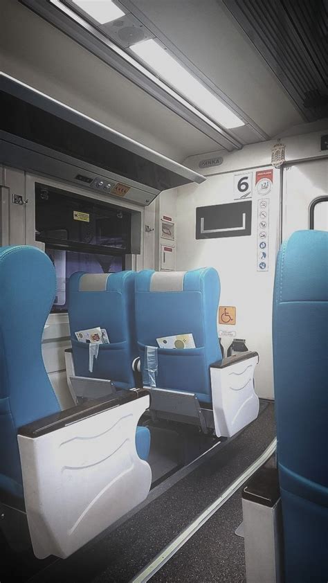 An Empty Train Car With Blue And White Seats