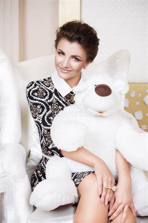 Beautiful Brunette Rich Saucy Woman In Elegant Dress Sitting On A Chair In A Room With Classic