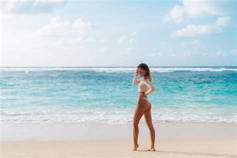 Backside View Of Girl With Booty In Beige Colour Bikini Resting On Deserted Beach Stock Image