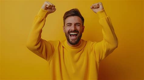 Premium Photo A Man In A Yellow Shirt Is Raising His Fists Up In The