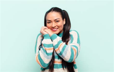 Mujer latina que se siente enamorada y se ve linda adorable y feliz sonriendo románticamente