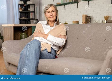 Blonde Mid Aged Woman Sitting On The Sofa At Home Stock Image Image