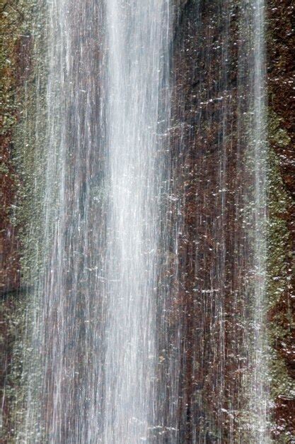 Premium Photo | Small spring mountain waterfall and rock behind