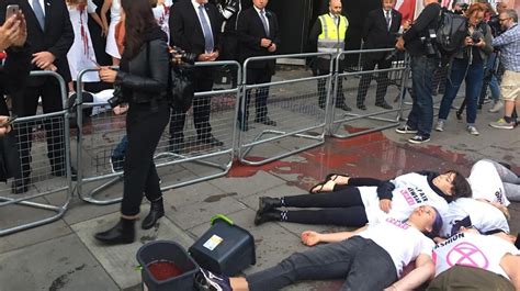 Extinction Rebellion Protesters Covered In Fake Blood Glue Themselves