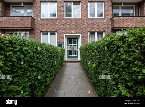 Front Side Of Apartment House Entrance With Hedges And Pathway Stock