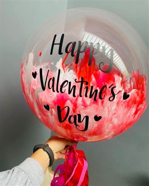 A Person Holding A Balloon With The Words Happy Valentine S Day Written