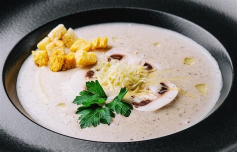 Sopa cremosa de champiñones con champiñones en negro Foto Premium