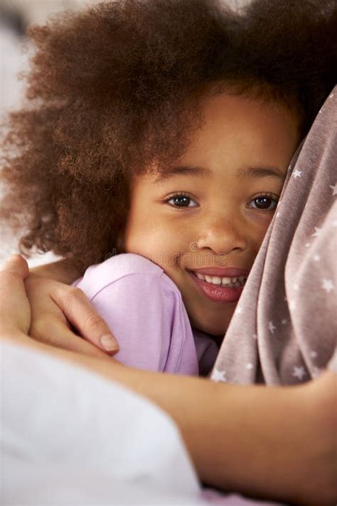 Retrato De Una Hija Abrazando A Una Madre Usando Pijamas En La Cama En