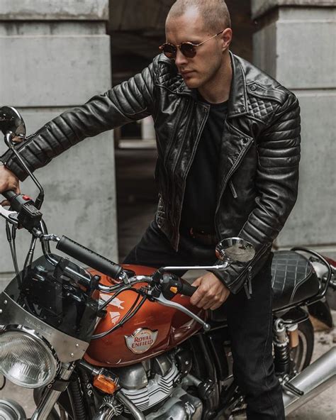 A Man Sitting On Top Of A Motorcycle Wearing Sunglasses And A Leather Jacket With His Hand On