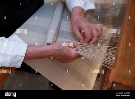 Close Up On The Hands Of A Man Weaving A Fabric From Flax Fibers With