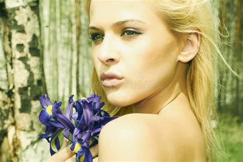 Mooie Blonde Vrouw Met Blauwe Bloemen In Een Bos Stock Afbeelding Image Of Emotie Groen