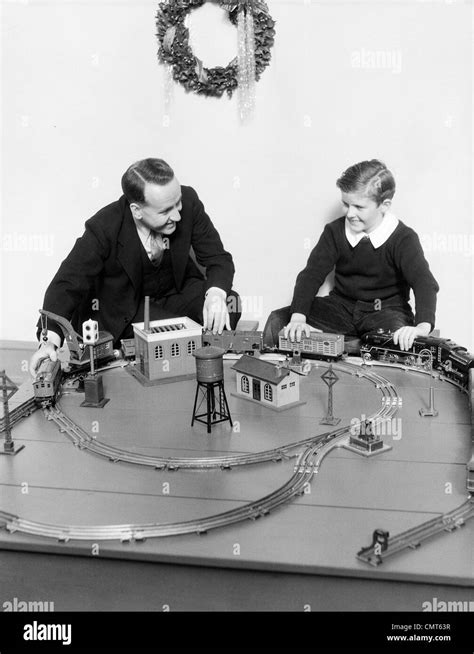 1930s FATHER AND SON PLAYING WITH CHRISTMAS TOY TRAIN SET Stock Photo ...