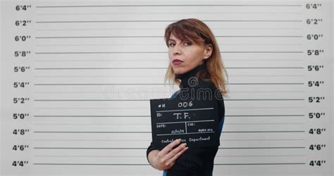 Mugshot Of Adult Woman With Long Wavy Hair Turning Head While Standing