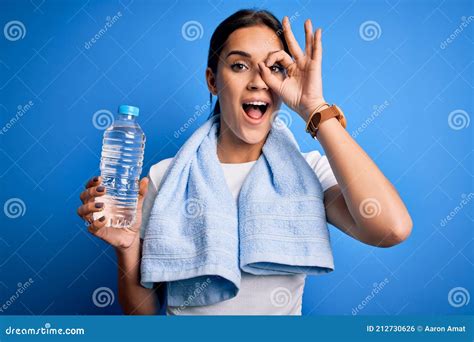 Joven Y Hermosa Deportista De Brunette Usando Toalla Bebiendo Botella De Agua Para Refrescarse