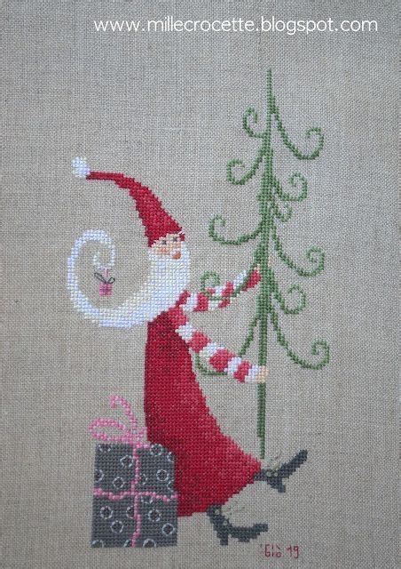 A Cross Stitch Christmas Scene With Santa Carrying Presents