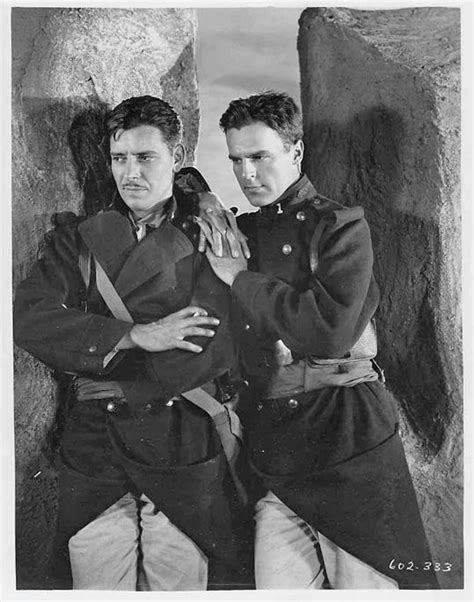 Two Men In Uniforms Standing Next To Each Other