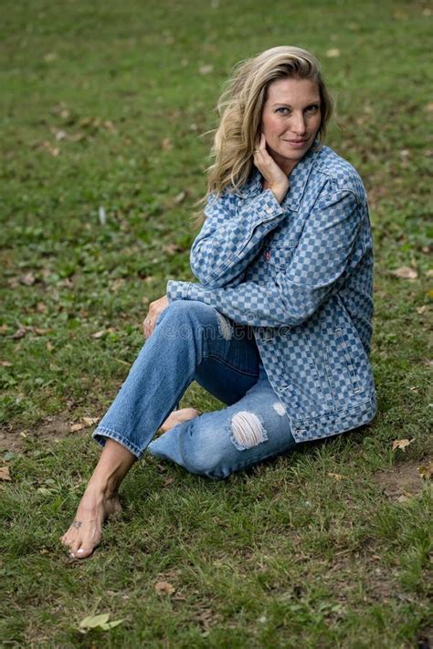Blonde Beauty Basks In Late Summer Sunlight Exuding Elegance Amidst Lush Greenery Stock Photo