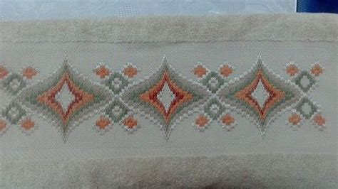 A White Towel With Orange And Green Designs On It