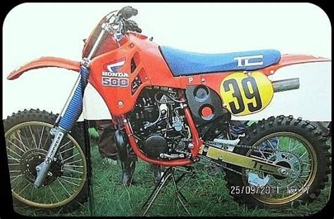 An Orange Dirt Bike Parked In The Grass