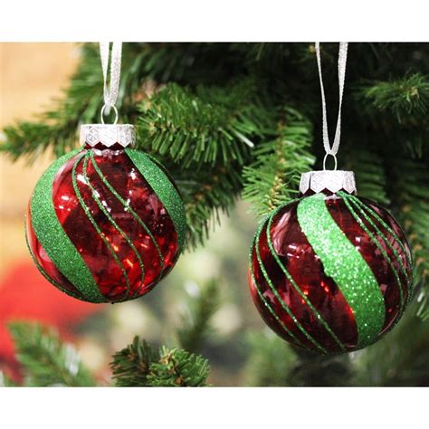 Two Ornaments Hanging From A Christmas Tree With Green Red And White