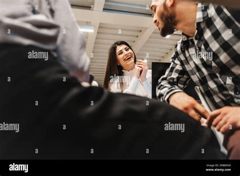 Stunning Brunette Female Employee Having Fun Conversation With Her Colleague At The Classroom