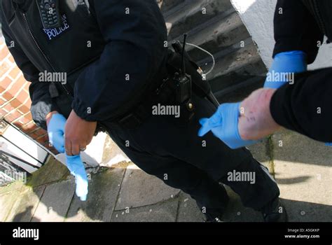 Police Officer Wearing Plastic Gloves Prior To Undertaking Forensic