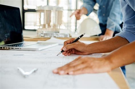 Premium Photo Cropped Image Of Engineers Drawing Blueprint In Office