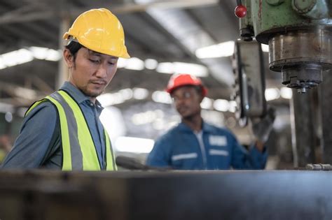 Trabajadores Asiáticos Y Fábrica De Hombres Africanos Que Trabajan En