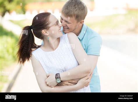 Beautiful Young Couple Hugging Each Other Tightly Laughing And Looking