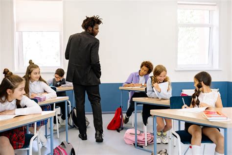 Teacher Standing Among Students in Classroom · Free Stock Photo