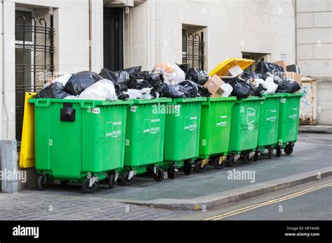 Overflowing Commercial Wheelie Bin Rubbish Bins On City Centre Street