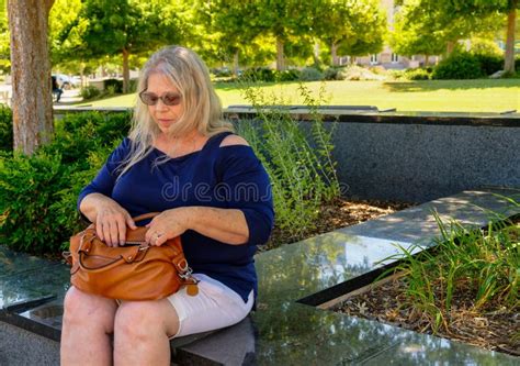 Elderly Woman Sitting On A Park Bench Looking At Her Purse Stock Image Image Of White Mature