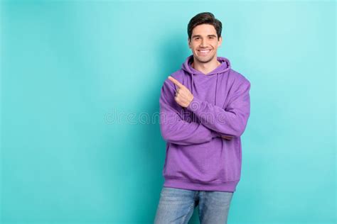 Photo Of Funky Attractive Young Man Wear Purple Hoodie Smiling Pointing Finger Empty Space