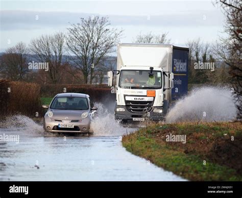 Vehículos conducidos a través de una carretera inundada en Aldingbourne