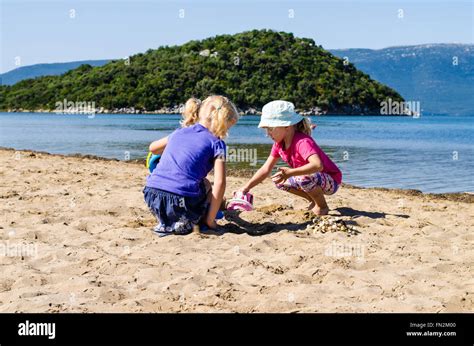 Beautiful Blond Girls Playing In Sand On The Beach Stock Photo Alamy