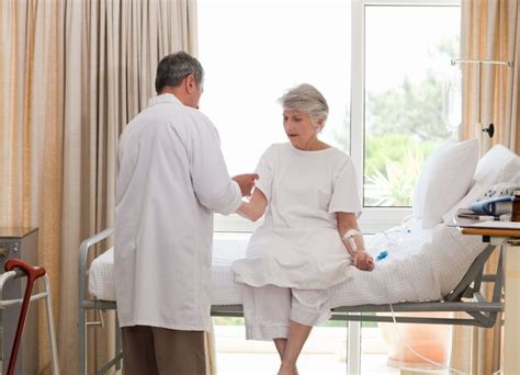 Un médecin mature prend la tension artérielle de son patient Photo Premium