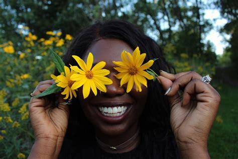 African American woman with flowers in park · Free Stock Photo