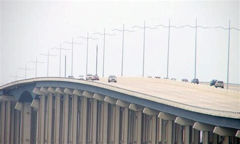 An Overpass With Cars Driving On It And Lots Of Tall Poles In The