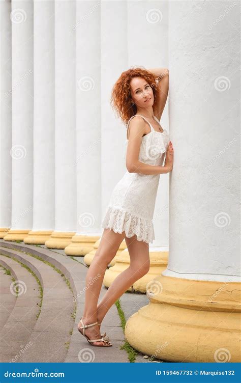 Close Up Well Groomed Red Haired Slim Girl Posing Near White Columns