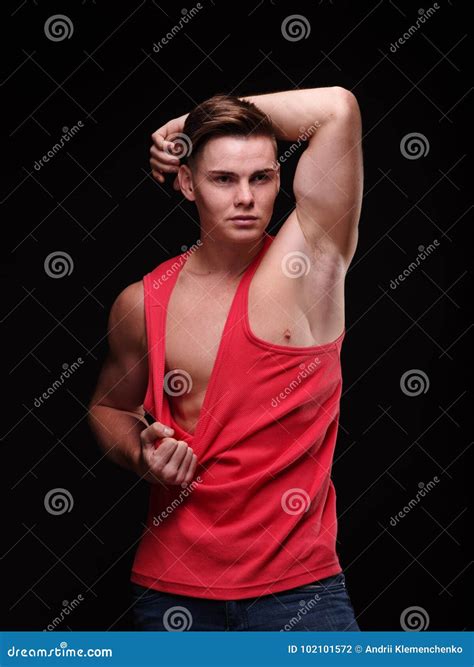 Healthy Beautiful Young Man Pulling His Red T Shirt On A Black