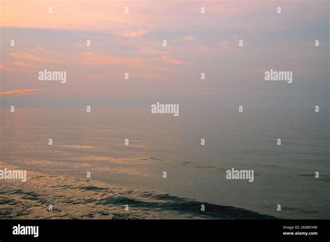 Pink Smoky Sunset Over Water With Clouds Stock Photo Alamy