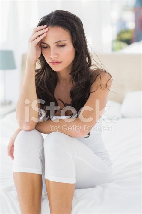 Worried Brunette Sitting On Bed Stock Photo Royalty Free FreeImages