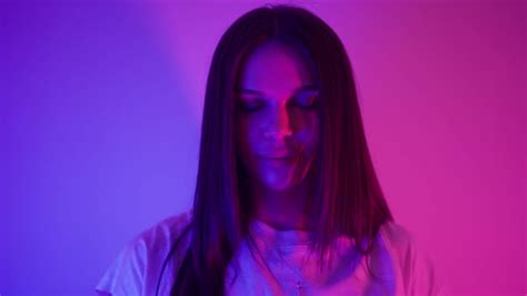 Attractive Brunette Woman Opens Her Eyes And Looks Seductively In Neon Lighting Stock Footage