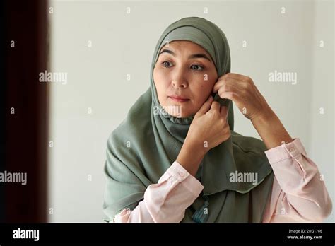 Portrait Of Mature Muslim Woman Putting On Silk Teal Hijab Stock Photo Alamy