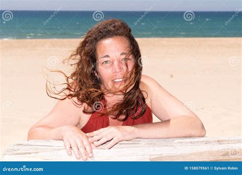 Brunette Cheery Happy Pleased Gorgeous Attractive Woman Lying Outdoors At Sea Beach In Summer