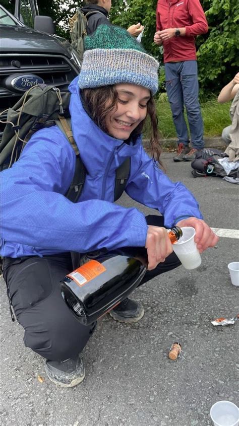 A Person Kneeling Down And Pouring Something Into A Cup